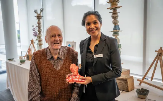 Right: Resident and artist Noel Belfrage with staff member Dara Duch who is holding the clay sculpture he created.