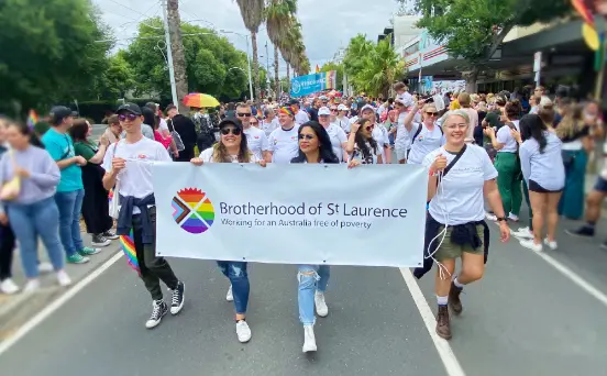 A group of BSL staff holding a BSL banner and marching at the Midsumma Pride March
