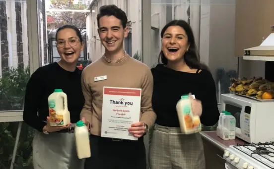 3 people at the National Volunteer Week breakfast club holding breakfast items