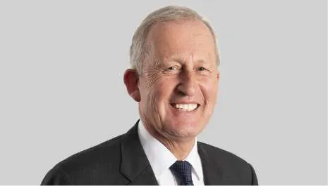 A headshot of BSL Board Chair Stephen Newton AO. He is wearing a charcoal suit and navy blue tie on white dress shirt.