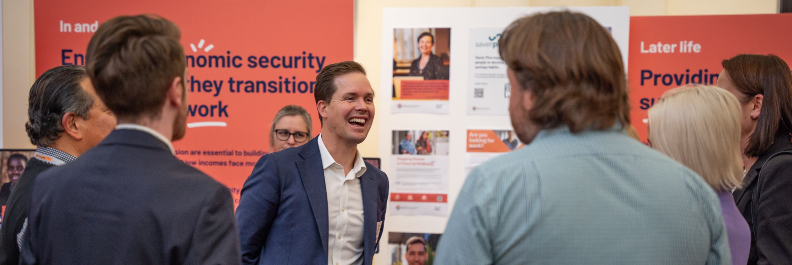 BSL Executive Director Travis McLeod at the BSL expo. He is laughing and talking to someone who has their back turned to the camera.